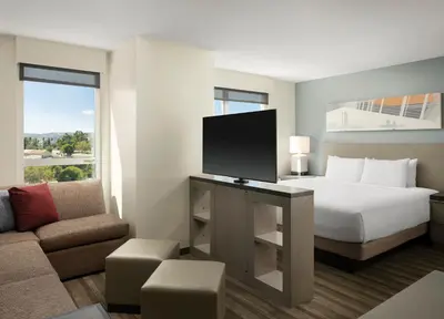 a hotel room with a bed and a flat screen tv at Hyatt House LA - University Medical Center in Los Angeles
