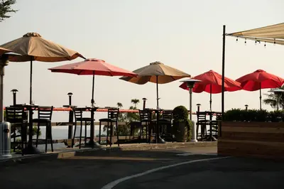 a group of tables and chairs with umbrellas at Hollywood Hills Hotel in Los Angeles