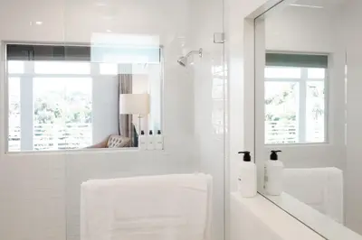 a white bathroom with a sink and a mirror at Hollywood Hills Hotel in Los Angeles