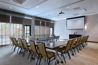 a conference room with a table and chairs and a screen at Springhill Suites by Marriott Anaheim Maingate in Anaheim