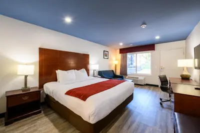 a hotel room with a large bed and a desk at Hyland Inn near Pasadena Civic Center in Pasadena