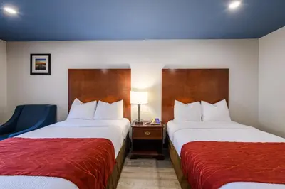 a hotel room with two beds and a chair at Hyland Inn near Pasadena Civic Center in Pasadena