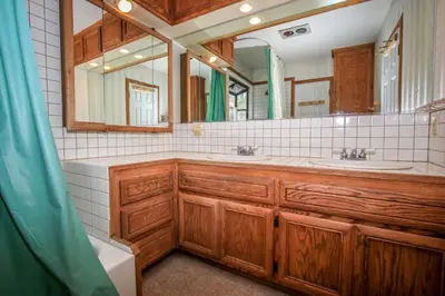 a bathroom with two sinks and a large mirror at A Big Olympic Getaway apts in Big Bear Lake