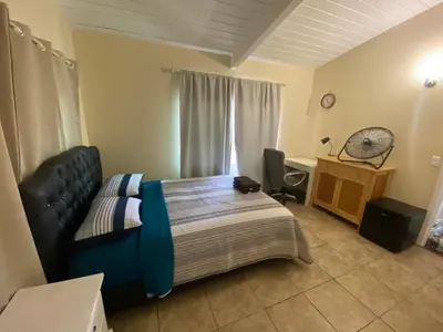 a bedroom with a bed and a desk and a fan at Casa Tranquila in Santa Ana