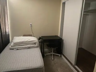 a small bedroom with a bed and a desk at Casa Tranquila in Santa Ana