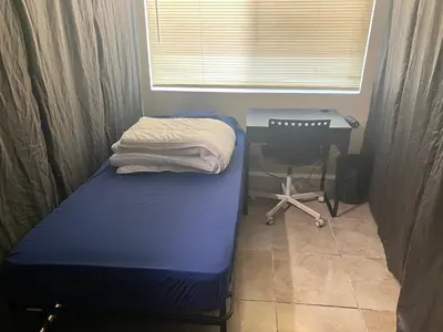 a bed in a room with a desk and a chair at Casa Tranquila in Santa Ana