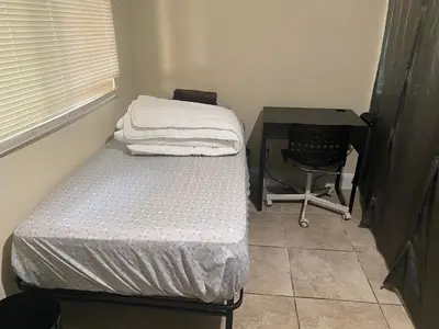 a small bedroom with a bed and a desk at Casa Tranquila in Santa Ana