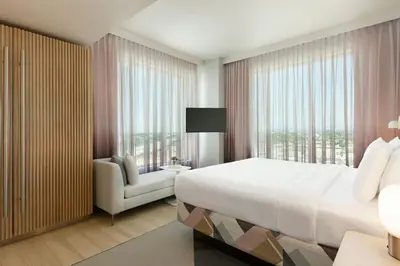 a bedroom with a large bed and a large window at The Viv Hotel, Anaheim, a Tribute Portfolio Hotel in Anaheim