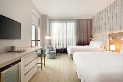 a hotel room with two beds and a flat screen tv at The Viv Hotel, Anaheim, a Tribute Portfolio Hotel in Anaheim