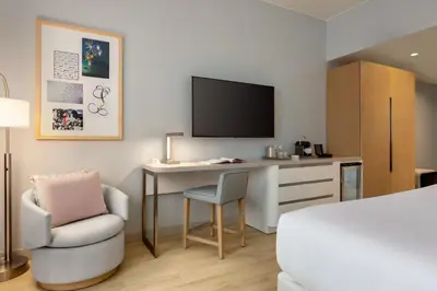 a room with a desk with a tv and a chair at The Viv Hotel, Anaheim, a Tribute Portfolio Hotel in Anaheim