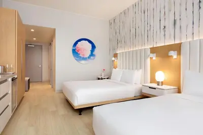 a hotel room with two beds and a kitchen at The Viv Hotel, Anaheim, a Tribute Portfolio Hotel in Anaheim