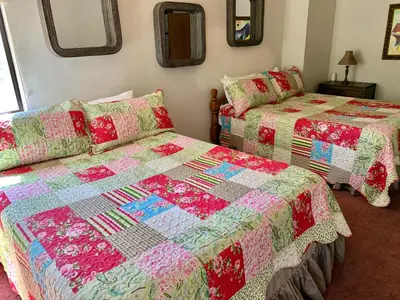 a bedroom with two beds and a quilt at Grey Squirrel Resort in Big Bear Lake