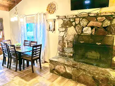 a dining room with a table and a stone fireplace at Grey Squirrel Resort in Big Bear Lake