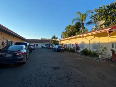a parking lot with cars parked next to a building at Sands Inn in South Gate