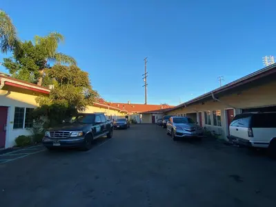 a parking lot with cars parked in front of a building at Sands Inn in South Gate