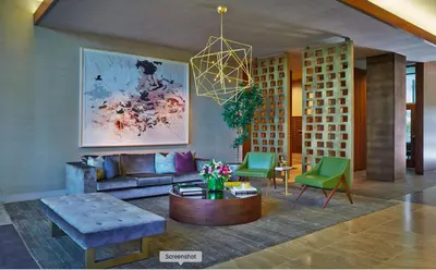 a living room with a couch and green chairs at Cityscape Luxury High-Rise 1-Bedroom in Los Angeles