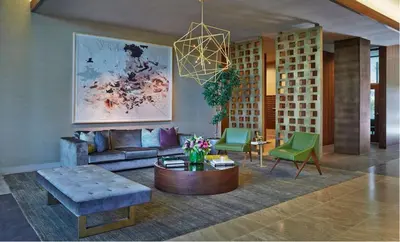 a living room with a couch and green chairs at Cityscape Luxury High-Rise 1-Bedroom in Los Angeles