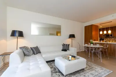 a living room with a white couch and a table at Cityscape Luxury High-Rise 1-Bedroom in Los Angeles