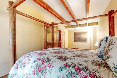 a bedroom with a bed with a floral bedspread at Sky High Cabin in Crestline