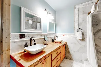 a bathroom with two sinks and a mirror at Sky High Cabin in Crestline