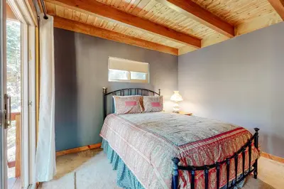 a bedroom with a bed and a window at Sky High Cabin in Crestline