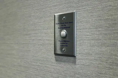 a metal elevator button on a wooden wall at Homewood Suites By Hilton Santa Clarita/Valencia, Ca in Santa Clarita