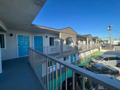 a balcony of a building with cars parked in a parking lot at Arlo Motel near LAX, SoFi Stadium in Inglewood