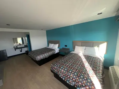 a hotel room with two beds and blue walls at Arlo Motel near LAX, SoFi Stadium in Inglewood