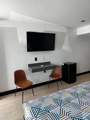 a room with two chairs and a television on a wall at Arlo Motel near LAX, SoFi Stadium in Inglewood