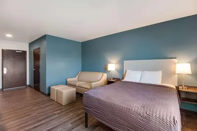 a hotel room with a bed and a chair at WoodSpring Suites Bakersfield Airport in Bakersfield