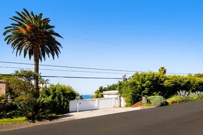 a street with a palm tree and a white fence at 50 PCT OFF! Malibu Ocean Escape, Pool, Walk to Beach in Malibu