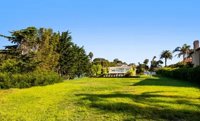 a large grass field with a house in the background at 50 PCT OFF! Malibu Ocean Escape, Pool, Walk to Beach in Malibu