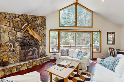 a living room with a large stone wall at Babbling Brook in Lake Arrowhead