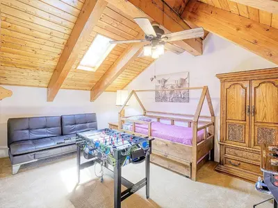 a bedroom with a bed and a couch and a table at Kid's Paradise! Ball Pit 2 Lofts Lakeview 5 bd, 3ba in Lake Arrowhead