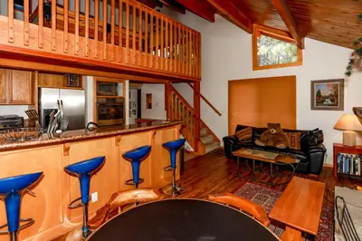 a kitchen and living room with a bar in a cabin at Mountain Adventure - 1931 by Big Bear Vacations in Big Bear Lake