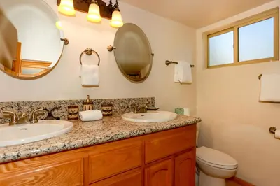 a bathroom with two sinks and a mirror at Mountain Adventure - 1931 by Big Bear Vacations in Big Bear Lake