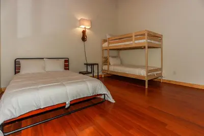 a bedroom with a bed and a wooden floor at Shasta Mountain Cabin - 1916 by Big Bear Vacations in Big Bear City