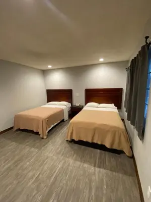 a room with two beds and a window at Sandman Motel in Los Angeles