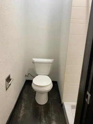 a bathroom with a white toilet in a stall at Sandman Motel in Los Angeles