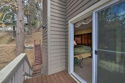 a door to a bedroom with a bed on a porch at Mountainside Cabin with Deck - 16 Miles to Skiing! in Lake Arrowhead