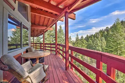 a porch of a cabin with a table and chairs at Lake Arrowhead Cabin with Deck and Stunning Mtn Views! in San Bernardino