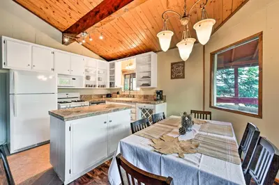 a kitchen with a table with a blue table cloth at Lake Arrowhead Cabin with Deck and Stunning Mtn Views! in San Bernardino