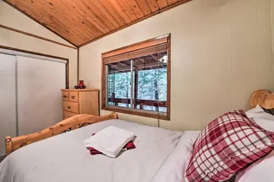 a bed in a room with a window and a bed sidx sidx sidx at Lake Arrowhead Cabin with Deck and Stunning Mtn Views! in San Bernardino