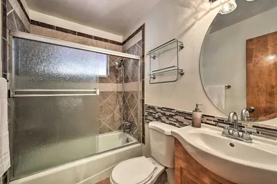 a bathroom with a toilet and a sink and a mirror at Lake Arrowhead Cabin with Deck and Stunning Mtn Views! in San Bernardino