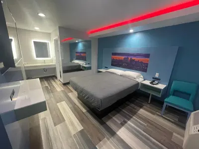 a bedroom with a bed and a blue wall at La Palma Motel, South Gate - Los Angeles area in South Gate