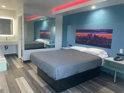 a bedroom with a large bed and a blue wall at La Palma Motel, South Gate - Los Angeles area in South Gate