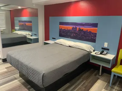 a bedroom with two beds and a red wall at La Palma Motel, South Gate - Los Angeles area in South Gate