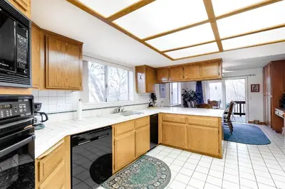 a kitchen with wooden cabinets and a black dishwasher at The House Of Light and Sky in Lake Arrowhead