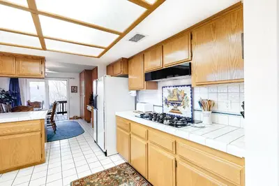 a kitchen with wooden cabinets and a white refrigerator at The House Of Light and Sky in Lake Arrowhead
