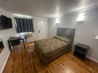 a small room with a bed and a desk and a desk at Seaway Motel in Los Angeles